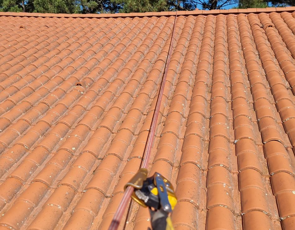 Travaux en hauteur sur une toiture avec des accroches par corde car accès difficile.